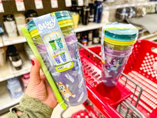 hand holding a zak designs tumbler set in front of a target cart