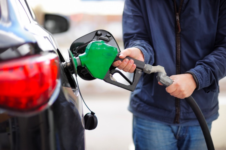 A person using a gas pump to fuel their vehicle. 