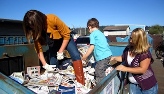 people in dumpster grabbing papers