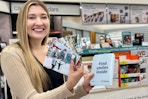 model holding photo prints at walgreens photo counter