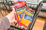 hand putting sargento cheese slices into shopping cart