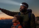 a dad with his son hiking while wearing a headlamp 