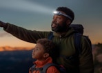 a dad with his son hiking while wearing a headlamp