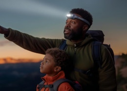 a dad with his son hiking while wearing a headlamp