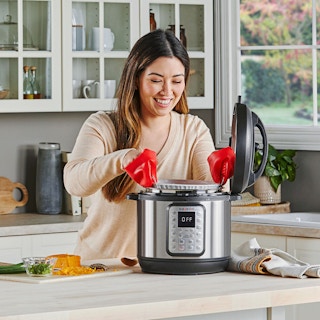 person lifting insert of instant pot in kitchen