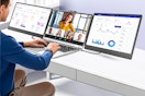 Lifestyle image of the SIAVIALA triple monitor being used by someone on his laptop for work