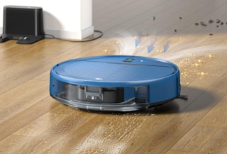 a blue robot vacuum on a charger next to a brick wall