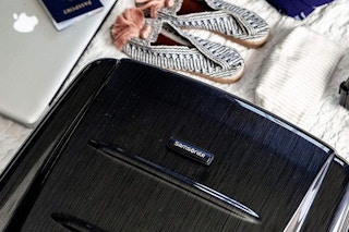 Samsonite luggage next to travel items