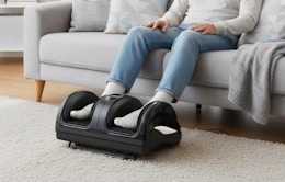 a person sitting on a couch with a foot massager