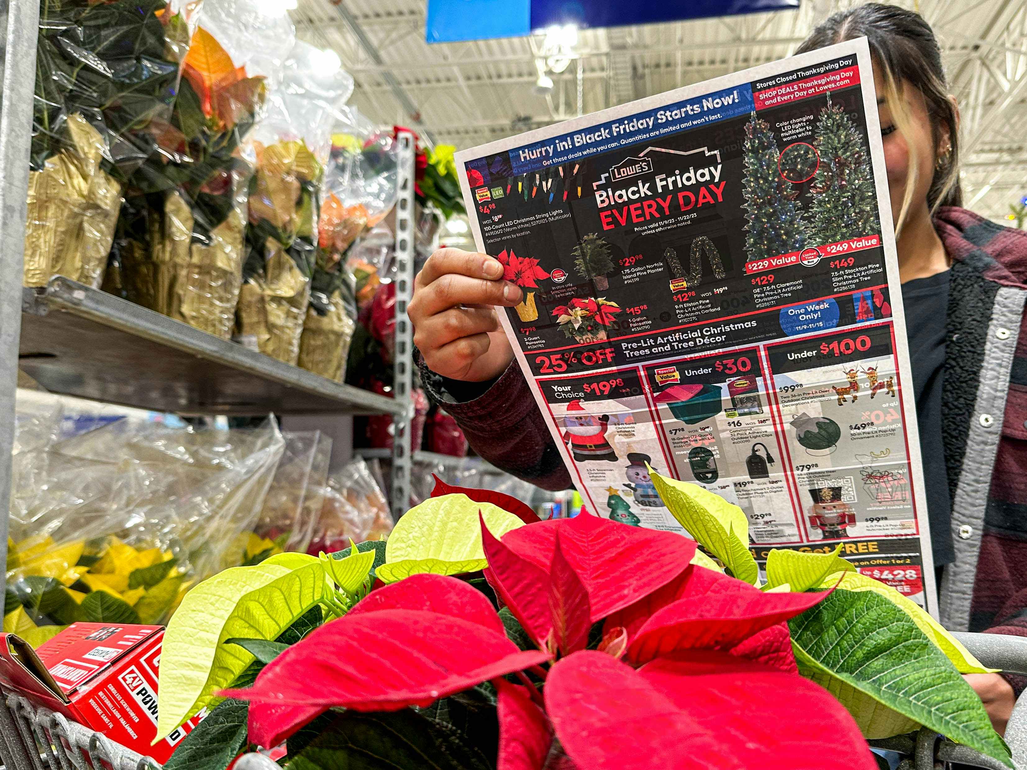 a person looking at a lowes black friday ad