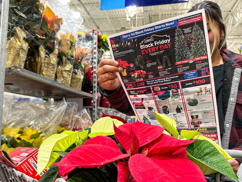 a person looking at a lowes black friday ad