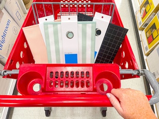 hand pushing target cart with room essentials storage bins
