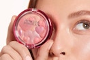 woman holding blush palette to her face