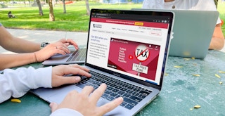 College students on their laptops, looking at an information page about 529 account enrollment