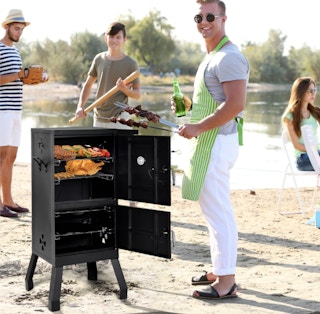 person barbecuing on the beach