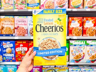 hand holding a box of frosted lemon cheerios in walmart cereal aisle