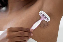 woman shaving her armpits