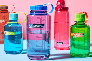5 Nalgene water bottles in front of a pink background