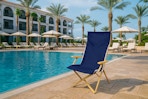 AI image created by ChatGPT of the Mainstays resort chair in a resort setting near a pool 