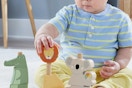 a baby playing with fisher-price animals