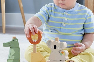 a baby playing with fisher-price animals