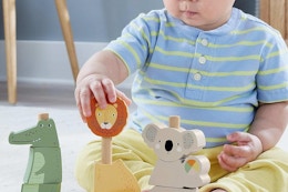 a baby playing with fisher-price animals