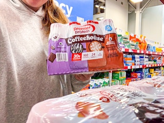 person holding a pack of premier protein coffeehouse drinks