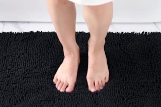 a person standing on a bathroom rug