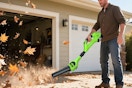 leaf blower being used on leaves in driveway