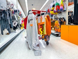 Halloween costumes hanging on the back of a Target shopping cart