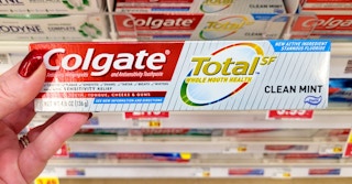 hand holding a box of colgate total toothpaste at kroger