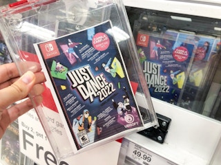hand grabbing a just dance 2022 for nintendo switch off a target shelf