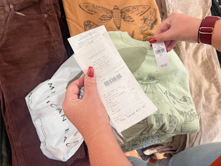someone comparing American Eagle receipt with the price tag on a shirt