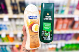 person holding softsoap and irish spring body wash in front of a shelf