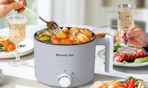 a grey electric hotpot with food inside 