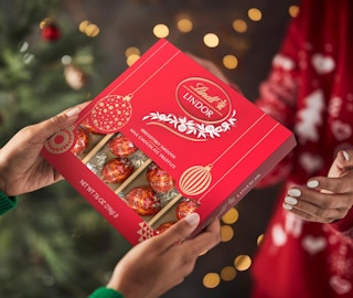 hands holding a red box of truffles
