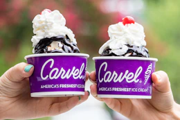 Two people holding up cups of Carvel ice cream