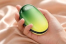 a hand holding a green hand warmer