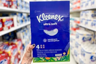 hand holding a 4-pack of kleenex ultra soft tissues in a target aisle