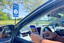 a person sitting in a car looking at their phone while in sam's club curbside pick up area 