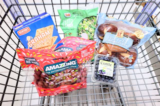 graham crackers, grapes, salad, blueberries, and pretzel buns in a cart