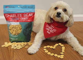 a dog laying next to a bag of dog treats