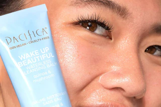a woman holding a pacifica cleansing balm