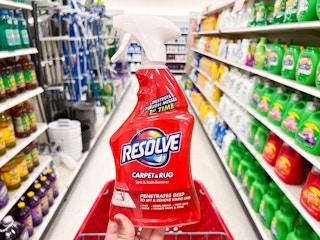 A hand holding a bottle of Resolve Stain Remover in an aisle at Target
