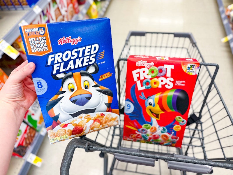 person putting frosted flakes into a cart with froot loops in it