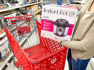a woman putting an Instant Pot into her Target cart at the store