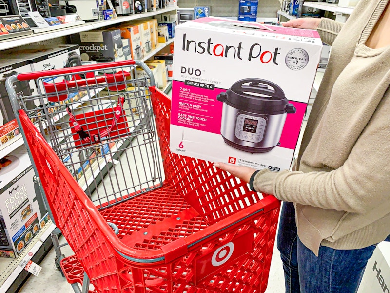 a woman putting an Instant Pot into her Target cart at the store
