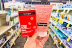 person holding neutrogena face wash and acne patches in an aisle