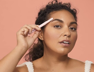 a woman shaving her eyebrow