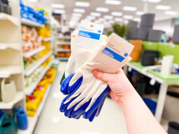hand holding 2 sets of gardening gloves in a target aisle